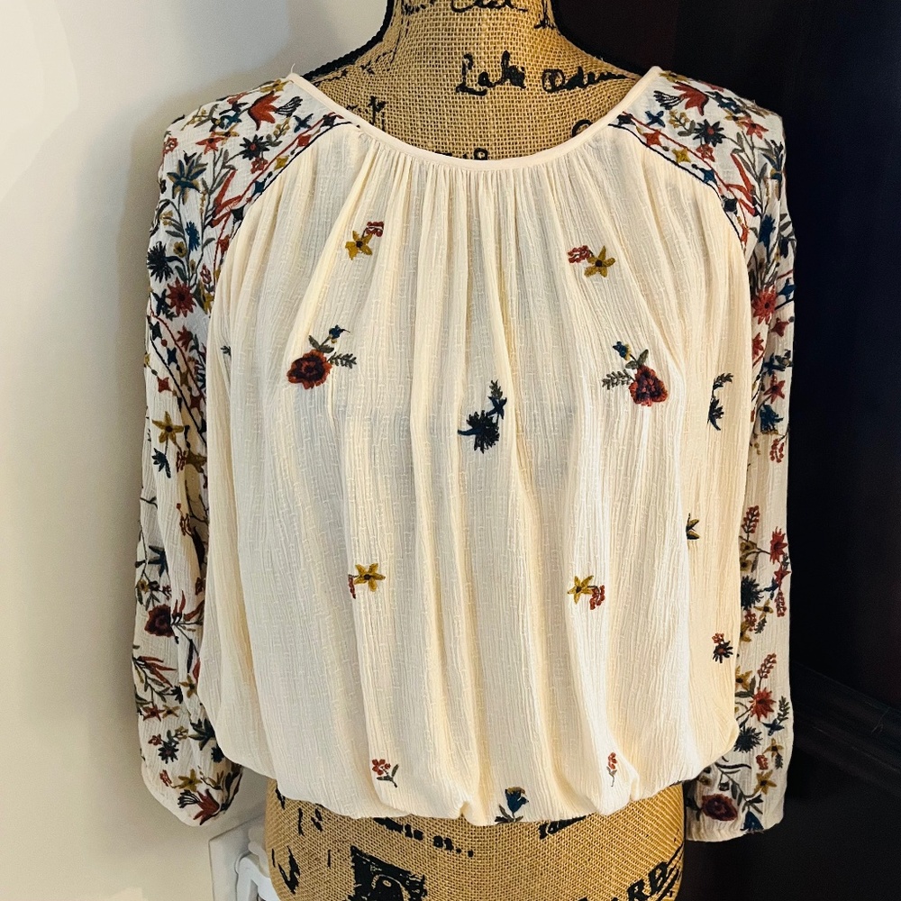 Free People cream colored top with floral embroidery.